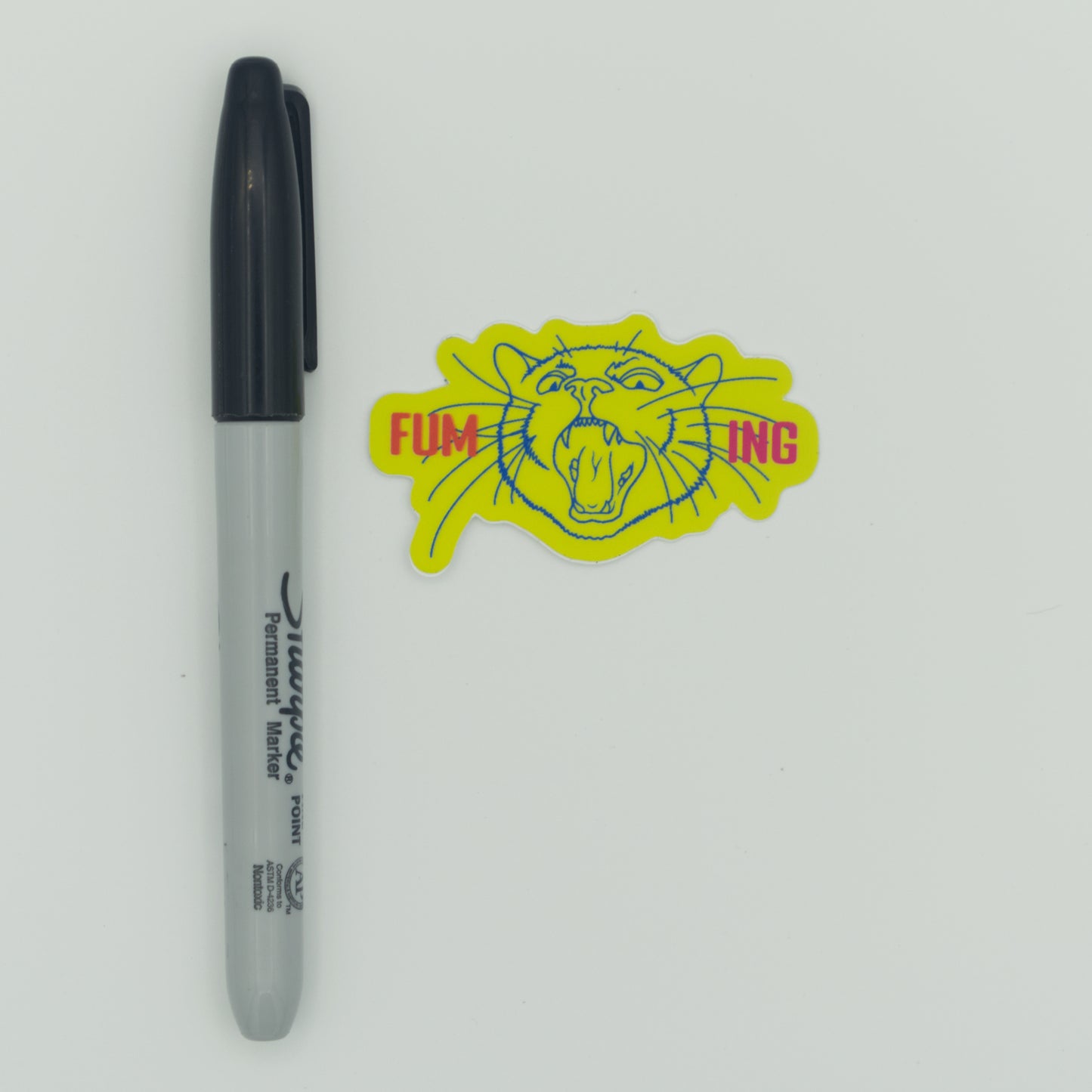 A neon yellow sticker next to a Sharpie for scale.