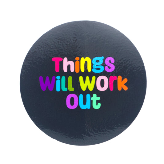 A photo of a glossy black sticker with the words "things will work out" and with each letter a different color