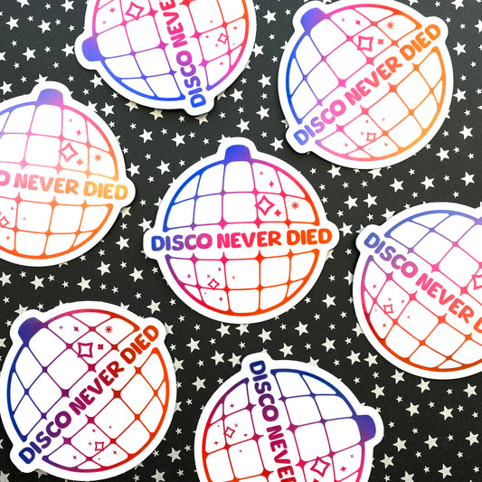 Holographic stickers of a disco ball featuring a purple to pink to orange gradient and the words "Disco Never Died" on it. One sticker is centered and six are arranged in a circle around it.