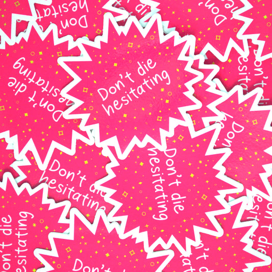 A pile of bright pink star-burst shaped stickers with the words "Don't die hesitating" in white handwriting surrounded by yellow stars and sparkles