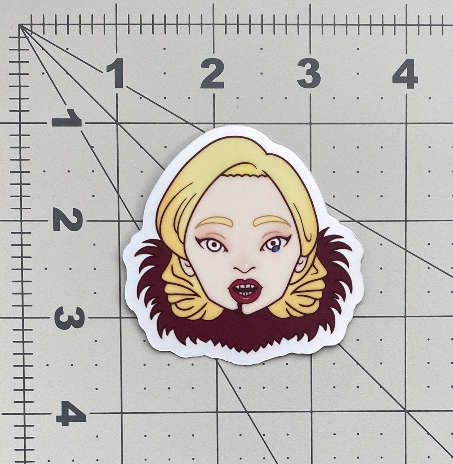 An illustrated sticker of Lady Gaga from American Horror Story on a ruler to show its dimensions